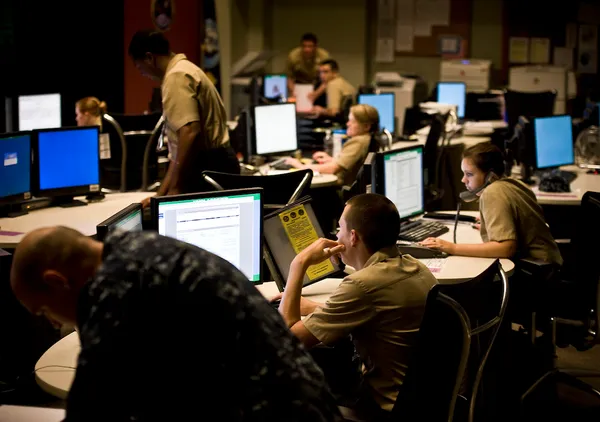 US Navy sailors monitoring cyber operations consoles.